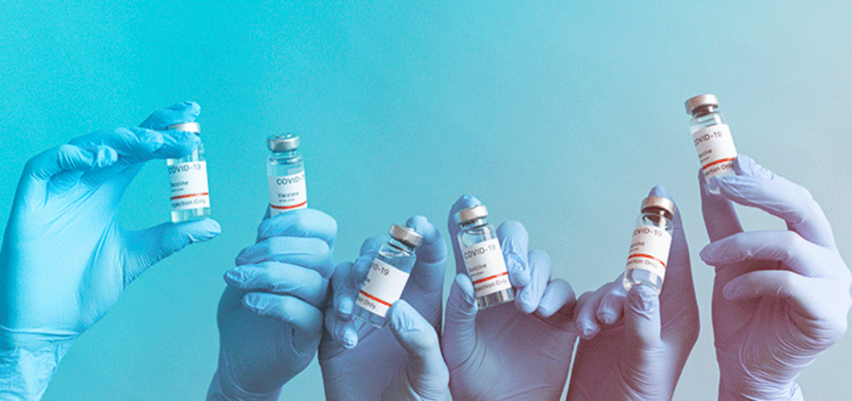 hands holding vials of COVID-19 vaccines